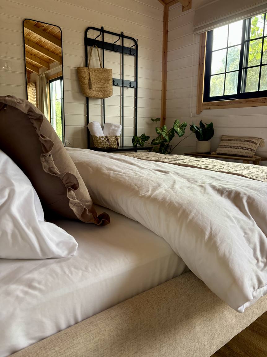 The double bed with white linen and a patterned pillow